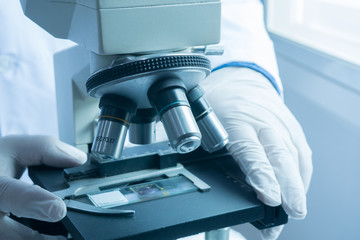 medical laboratory, scientist hands using microscope for chemistry test samples,examining samples and liquid,Medical equipment. microscope,Scientific and healthcare research background.vintage color