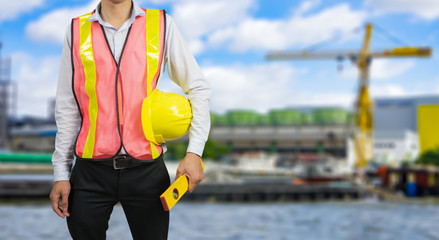 engineering management construction concept,engineer holding  hand a  yellow helmet and measure equipment security,Architects overseers on working site background ,for banner  website