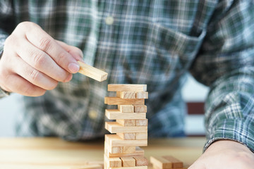 Planning, risk and strategy of project management in business, businessman and engineer gambling placing wooden block on a tower,construction with copy space,selective focus,vintage color