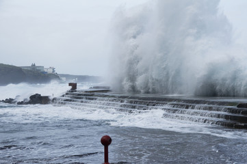 temporal de mar y olas chocando contra escollera
