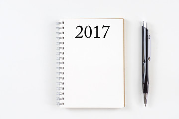 Top view 2017 goals list with notebook, pen on white background.