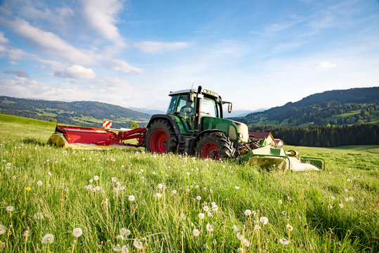 Moderne Landtechnik - Landwirt mäht Gras für Silage im Allgäu