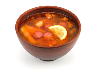 saltwort russian beef, pork and sausage soup solyanka with lemon, salami in plate isolated on white background