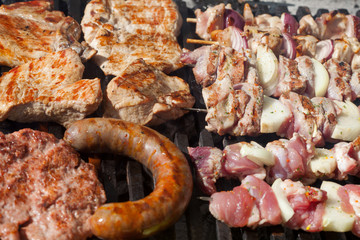 Assorted delicious grilled meat over the coals on a barbecue