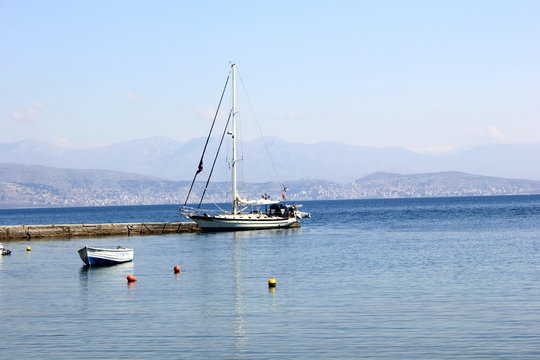 yacht moored in harbour with sea and mountain