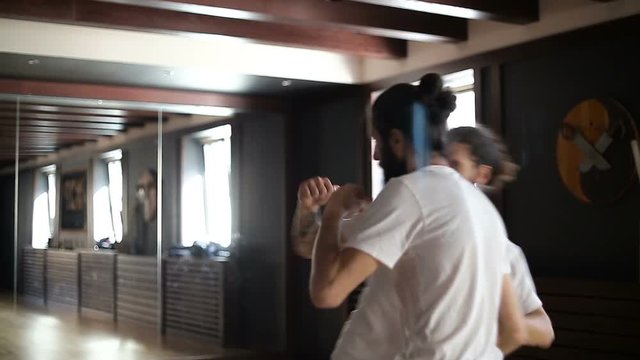 Twin brothers practice in Chinese martial arts in the training hall
