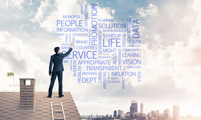 Young businessman standing on house roof and writing leadership 