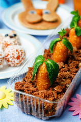 chocolate biscuit in a box and dried apricots cashew candies in the form of carrots