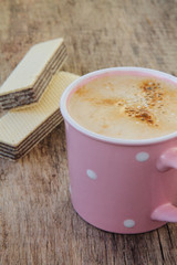 Hot coffee with delicious waffles on a wooden background