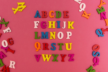 Children's alphabet on a pink background.