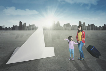 Woman and her daughter with paper plane