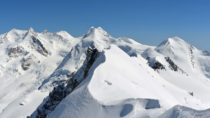 Fototapeta na wymiar Sci Alpinisti scalano il Breithon Centrale, vista dal Breithorn (Occidentale), Monte Rosa