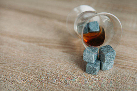 Stones for cooling whiskey and glases tulup on dark wooden background