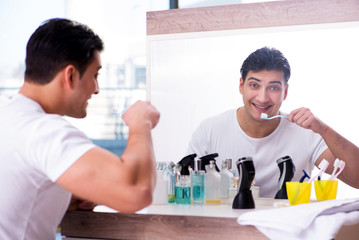 Handsome man brushing teeth in the morning