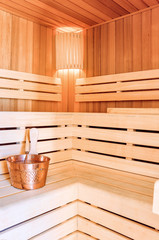 Sauna room. Wooden sauna interior with copper bucket. Bath accessories.   Finnish sauna of small size.