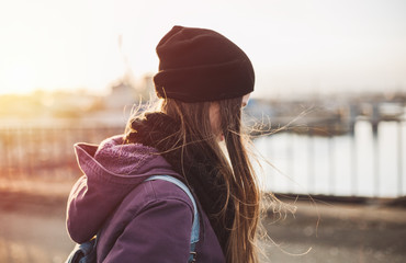 Hipster girl walking on the bridge at sunset