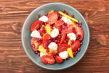 Tomato salad, mango and mozzarella with pomegranate seeds