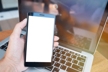Close up of a man holding and using smart phone with blank mobile and cup of coffee .Smart phone with blank screen and can be add your texts or others on smart phone.