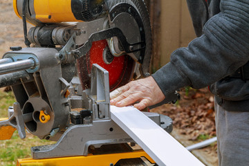 Side view of mid adult manual worker cutting wood