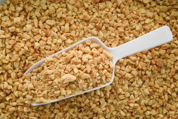 Chopped or crushed peanuts with a plastic  scoop