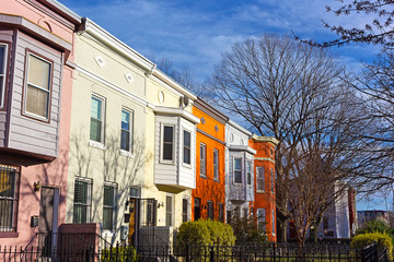 Colorful residential row houses under bright afternoon sun. Historic urban architecture of Shaw neighborhood in Washington DC.