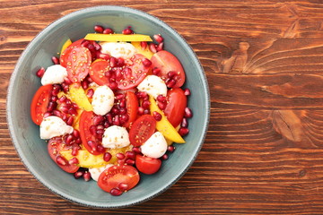 Tomato salad, mango and mozzarella with pomegranate seeds