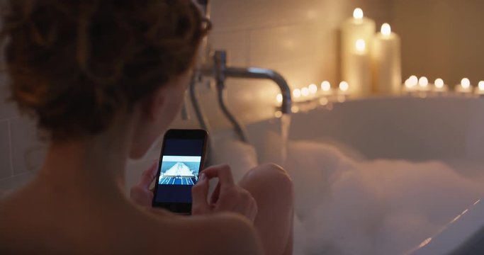 Sexy Woman using smartphone browsing social media inspirational travel photos mindfulness travel concept at home