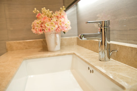 Closeup of sink and faucet in modern bathroom.