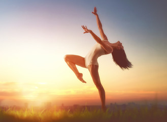 Fototapeta premium woman is dancing on sunset