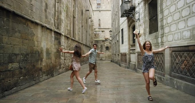 Diverse group of friends dancing freestyle in European City summer dress in rainy weather celebrating travel adventure