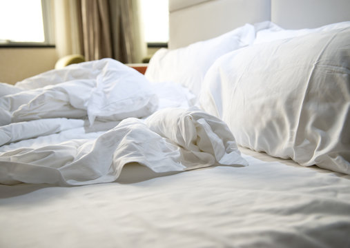 close up of messy bedding sheets and pillow