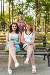 Fototapeta na wymiar Mom in the park with older daughters 