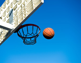 A basketball field goal with the sky in background.