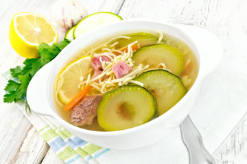 Soup with zucchini and noodles on board