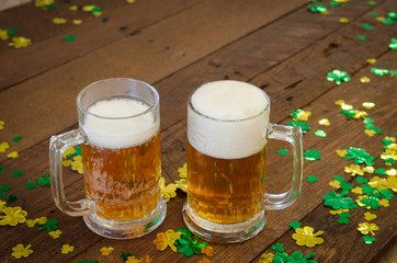 A rustic St Patrick's Dayimage with shamrock confetti and beer stiens