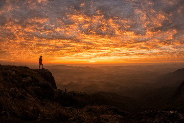 Obraz premium hiker celebrating success on top of a mountain in a majestic sunset