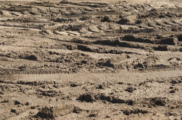 A background of mud with tire tracks