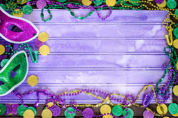 Vibrant Mardi Graw background with masks, beads and coins and copy space
