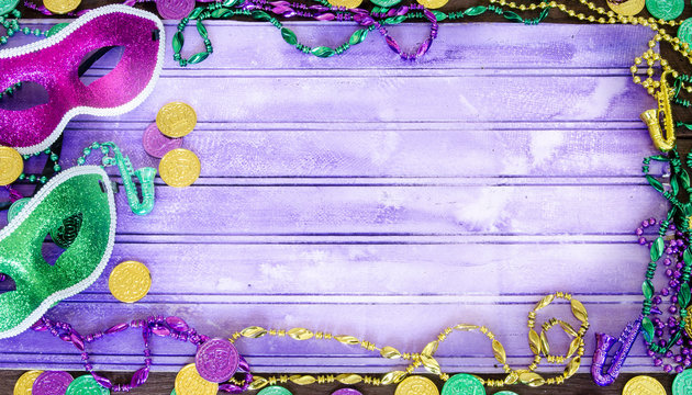 Vibrant Mardi Graw background with masks, beads and coins and copy space
