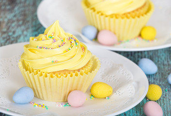 Yellow Easter cupcake with candy and sprinkles