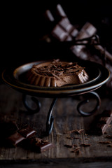 Panna cotta with chocolate on black old background