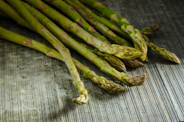 Asparagus spears on a textured slate surface with dramatic lighting