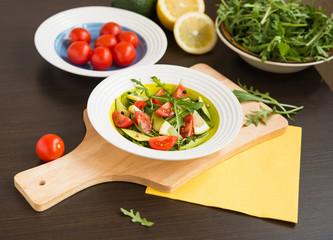 Healthy food. Fresh salad of arugula with cherry tomatoes and avocado