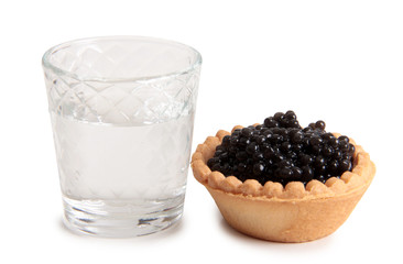Fish caviar and glass of vodka on white background