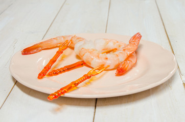 Pink shrimp appetizers on picks on a vintage plate