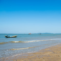 Fototapeta premium Wooden boat on a beach white blue sky for background.