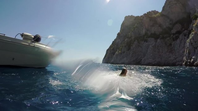 Beautiful Girl Friends jumping into deep blue sea from boat wild free healthy lifestyle 