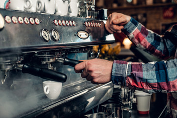  Close up image of a man making coffee.