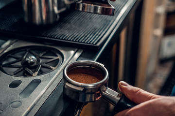  Close up image of a man making coffee.