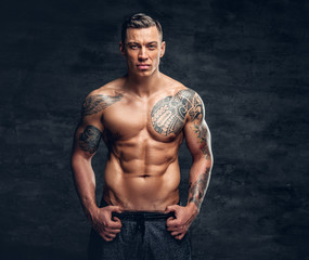 A man with tattoo on his chest over grey background.